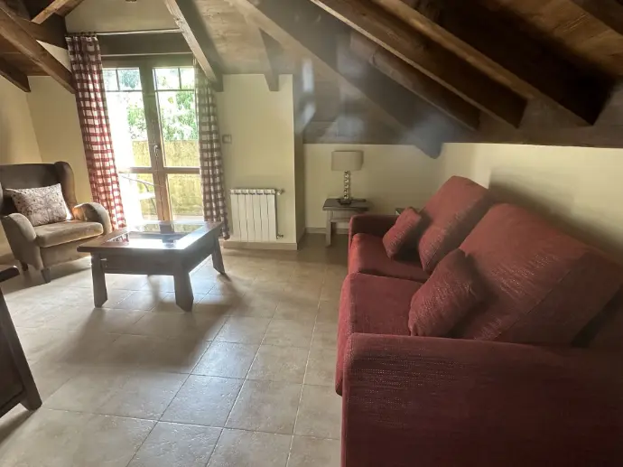 Sala de estar con sofá y vigas de madera