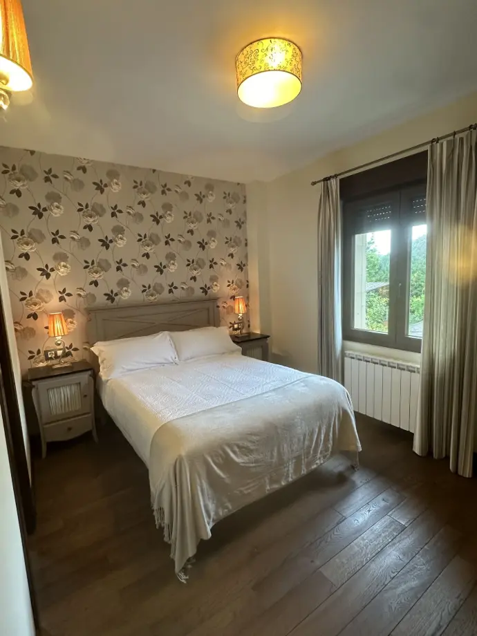 Habitación con cama de matrimonio y suelo de madera